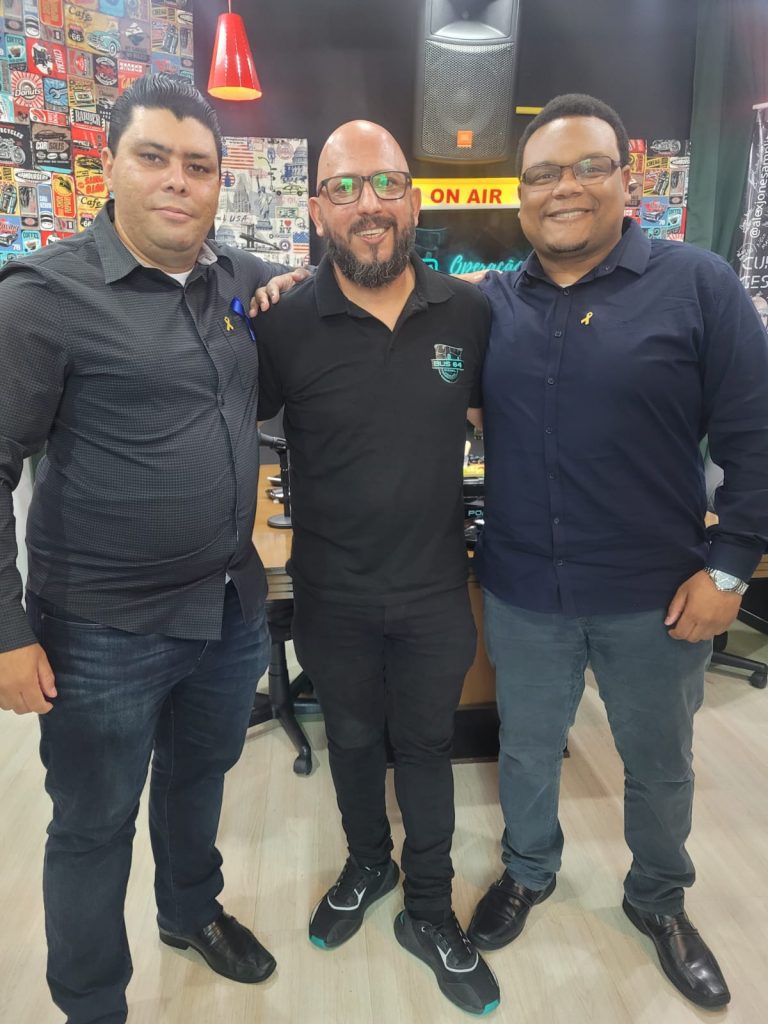 Esquerda para direita: Fabio Trindade, Alex Jones (ao centro) e Guilherme Augusto.
