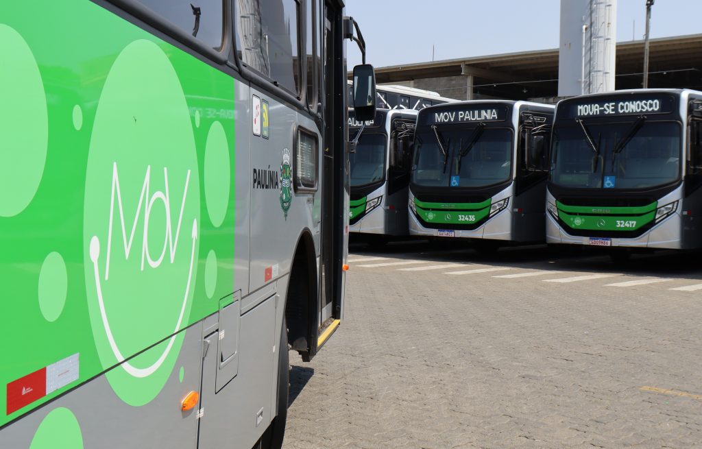 Ônibus estacionados na garagem da Rápido Sumaré, em Paulínia com destaque lateral ao logotipo do sistema de transporte da cidade.
