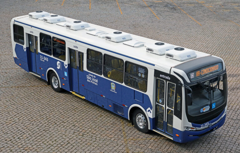 Ônibus estacionado na garagem da Auto Viação São José dos Pinhais com letreiro em escrita AR CONDICIONADO